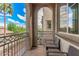 A cozy balcony with wrought iron railing and outdoor seating offers views of lush landscaping and blue skies at 1756 E Bridgeport Pkwy, Gilbert, AZ 85295