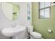 Charming half-bath features a pedestal sink, modern fixtures, and soothing green walls at 1756 E Bridgeport Pkwy, Gilbert, AZ 85295