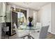 Bright dining room with a modern glass table, white chairs, wine cooler, and patio access at 1756 E Bridgeport Pkwy, Gilbert, AZ 85295