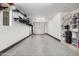 Spacious garage with epoxy flooring, overhead lighting, and wall shelving for optimal organization at 1756 E Bridgeport Pkwy, Gilbert, AZ 85295