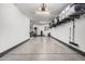 A spacious garage with epoxy flooring, overhead lighting, and built-in shelving for storage at 1756 E Bridgeport Pkwy, Gilbert, AZ 85295