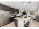 Modern kitchen features dark cabinets, granite counters, stainless steel appliances, and island with bar stool seating at 1756 E Bridgeport Pkwy, Gilbert, AZ 85295