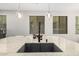 The kitchen island boasts a granite countertop, a black sink, and stylish pendant lighting at 1756 E Bridgeport Pkwy, Gilbert, AZ 85295