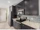 Contemporary kitchen boasts dark cabinets, stainless steel appliances, and decorative tile backsplash at 1756 E Bridgeport Pkwy, Gilbert, AZ 85295