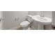 Powder room featuring modern fixtures including a pedestal sink and a toilet at 17637 W Rancho Dr, Litchfield Park, AZ 85340