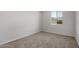 Inviting carpeted bedroom with a large window showcasing the neighborhood view, bright and airy space at 17637 W Rancho Dr, Litchfield Park, AZ 85340