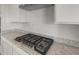 Modern kitchen cooktop featuring granite countertops and stainless steel hood at 17637 W Rancho Dr, Litchfield Park, AZ 85340