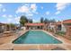 Community pool and hot tub with poolside seating and brick trimmed buildings in the background at 1951 N 64Th St # 69, Mesa, AZ 85205