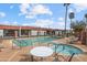 Community pool and hot tub with poolside seating, palm trees, and brick trimmed buildings at 1951 N 64Th St # 69, Mesa, AZ 85205