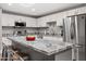 Bright kitchen boasting white cabinets, stainless steel appliances, and a large granite island with bar seating, great for gatherings at 1951 N 64Th St # 69, Mesa, AZ 85205