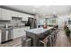 Spacious kitchen with white cabinets, stainless steel appliances, and a large island with seating that opens to the living room at 1951 N 64Th St # 69, Mesa, AZ 85205