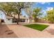 Large backyard boasts desert landscaping with patio, mature trees, and lush green lawn at 19601 N 14Th St, Phoenix, AZ 85024