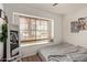 Bright bedroom with wood-look floors, a sunny window with blinds, and a decorative mirror at 19601 N 14Th St, Phoenix, AZ 85024