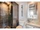 Modern bathroom features a stone-tiled shower, toilet, and clear glass vessel sink with wall-mounted faucet at 207 W Clarendon Ave # G18, Phoenix, AZ 85013