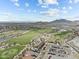 Aerial view showcasing the community golf course with clubhouse, parking, and surrounding landscape at 20718 W Colter St, Buckeye, AZ 85396