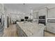 Modern kitchen featuring an island, granite countertops, and open layout to dining and living areas at 20718 W Colter St, Buckeye, AZ 85396