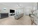 Bright living room featuring a fireplace, ceiling fan, and comfortable gray sectional sofa at 20718 W Colter St, Buckeye, AZ 85396