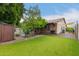 Expansive backyard features an artificial lawn, mature trees, a pool, outdoor kitchen, and a covered patio at 2164 W Megan St, Chandler, AZ 85224