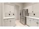 Bright kitchen showcasing stainless steel refrigerator, white cabinets, and tile backsplash at 2164 W Megan St, Chandler, AZ 85224