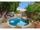 Inviting backyard pool features a rock surround, blue water and mature landscaping creating a private oasis at 2164 W Megan St, Chandler, AZ 85224