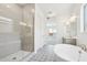 Modern bathroom featuring a soaking tub, glass-enclosed shower, and stylish tile flooring at 22685 E Saddle Way, Queen Creek, AZ 85142