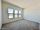Bright bedroom with three large windows and plush gray carpeting at 22685 E Saddle Way, Queen Creek, AZ 85142