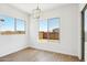 Bright dining room with wood flooring, two windows, and a modern chandelier at 22685 E Saddle Way, Queen Creek, AZ 85142