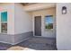 Welcoming entryway with a gray front door, a sidelight window, and a paved walkway at 22685 E Saddle Way, Queen Creek, AZ 85142