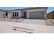 Welcoming one-story home with a gray garage door, drought-tolerant landscaping, and neutral colors at 22685 E Saddle Way, Queen Creek, AZ 85142