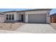 Charming single-story home with a gray garage door, desert landscaping, and a neutral color scheme at 22685 E Saddle Way, Queen Creek, AZ 85142