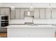 Kitchen features gray cabinetry, stainless steel appliances, and a center island with white countertops at 22685 E Saddle Way, Queen Creek, AZ 85142