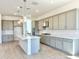 Bright kitchen boasts stainless appliances, ample gray cabinetry, and a center island with pendant lighting at 22685 E Saddle Way, Queen Creek, AZ 85142
