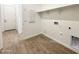 A functional laundry room features wood-look tile flooring and essential hookups for appliances at 22685 E Saddle Way, Queen Creek, AZ 85142