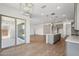 Open-concept living area with a modern chandelier, tile flooring, and sliding glass doors to the patio at 22685 E Saddle Way, Queen Creek, AZ 85142
