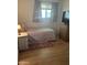 Simple bedroom with a bed, dresser and wooden flooring at 2530 W Berridge Ln # E201, Phoenix, AZ 85017