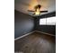 A bedroom with a ceiling fan and wood-look floors, featuring a window for natural light and neutral paint at 2551 W Berridge Ln # D6, Phoenix, AZ 85017
