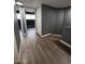 Hallway with wood-look floors leading to a bedroom and closet, featuring neutral paint and built in storage at 2551 W Berridge Ln # D6, Phoenix, AZ 85017