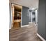 View of hallway leading to a bathroom and other rooms, featuring wood-look floors and grey walls at 2551 W Berridge Ln # D6, Phoenix, AZ 85017