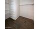 Inside a walk-in closet with wood-look floors and open white shelving on the left at 2551 W Berridge Ln # D6, Phoenix, AZ 85017