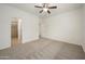 Large primary bedroom with ceiling fan, ensuite bathroom, and neutral carpeting at 2560 E Indian Wells Pl, Chandler, AZ 85249