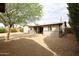 Expansive backyard featuring a desert landscape, mature tree, and covered patio at 3125 E Grovers Ave, Phoenix, AZ 85032
