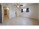 Bright bedroom featuring a ceiling fan, tile floors, a window, and access to the bathroom at 3125 E Grovers Ave, Phoenix, AZ 85032