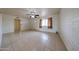 Bright living room featuring a ceiling fan, tile floors, and a front-facing window at 3125 E Grovers Ave, Phoenix, AZ 85032