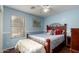 Charming bedroom offers a relaxing atmosphere with soft blue walls and wood-look tile at 33224 N Cat Hills Ave, San Tan Valley, AZ 85144