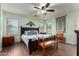 Comfortable bedroom with wood-look tile flooring, ceiling fan, and natural light at 33224 N Cat Hills Ave, San Tan Valley, AZ 85144