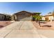 Exterior showcasing a desert landscape, palm trees, and a well-maintained driveway leading to a two-car garage at 33224 N Cat Hills Ave, San Tan Valley, AZ 85144