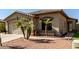 Image highlighting the front of a home with desert landscaping, including palm trees and gravel, alongside a two-car garage at 33224 N Cat Hills Ave, San Tan Valley, AZ 85144