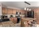 Well-equipped kitchen with granite countertops, black appliances, and stylish pendant lighting over the island at 33224 N Cat Hills Ave, San Tan Valley, AZ 85144