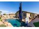 Backyard pool with water feature, basketball hoop, umbrella, and exterior view of the residence on a sunny day at 33224 N Cat Hills Ave, San Tan Valley, AZ 85144
