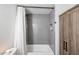 Bathroom featuring a shower/tub combo with tiled walls and wood-look storage cabinet at 3520 E Ludlow Dr, Phoenix, AZ 85032